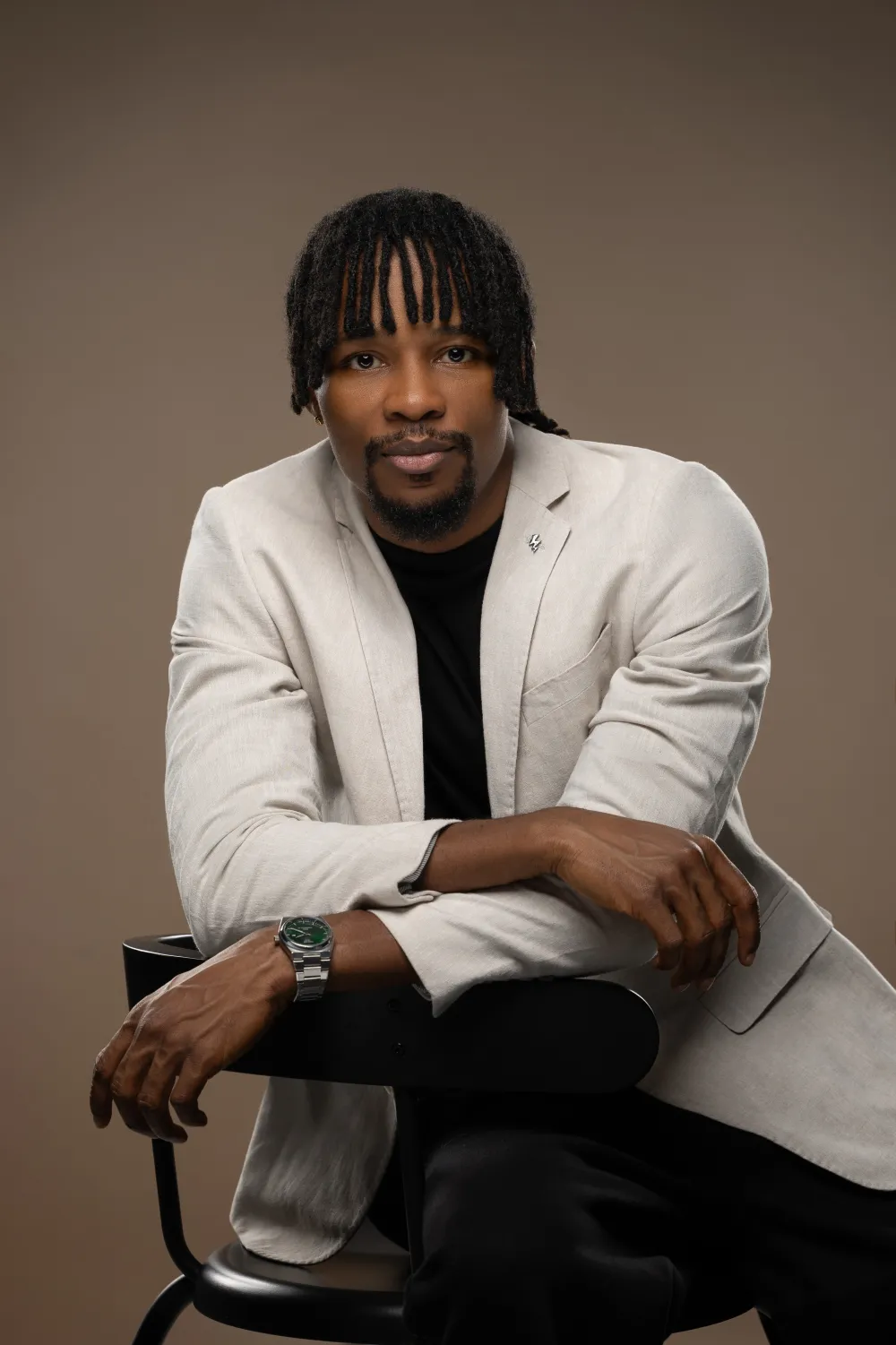 Ekene Eze seated in a cream blazer